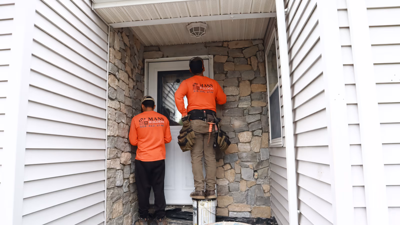 Mason installing natural stone veneer around a home's entryway