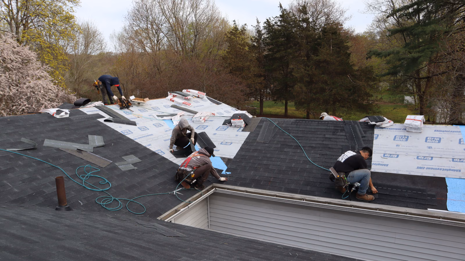 Roofing crew installing shingles