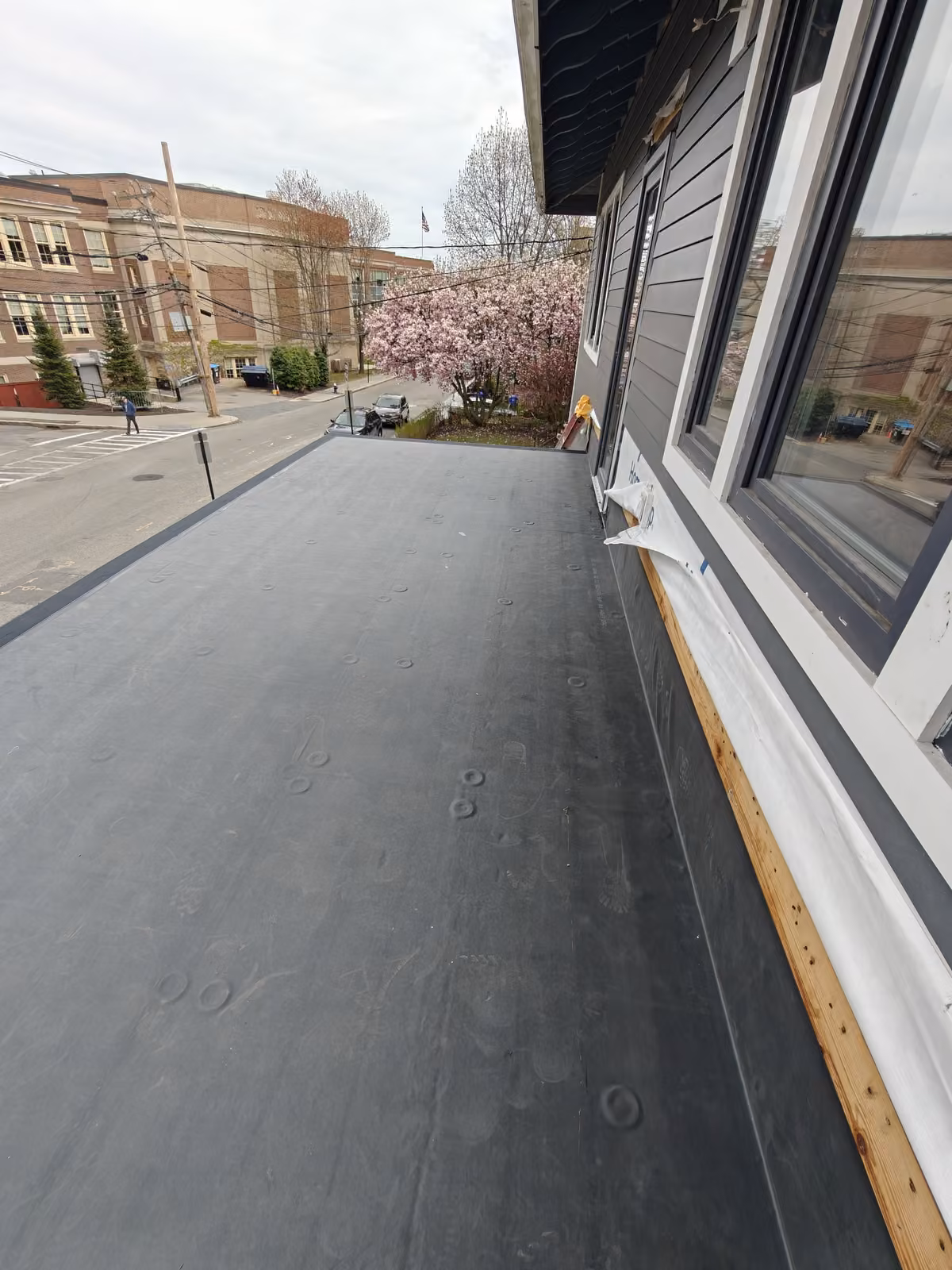 Smooth EPDM flat roof membrane along the second floor