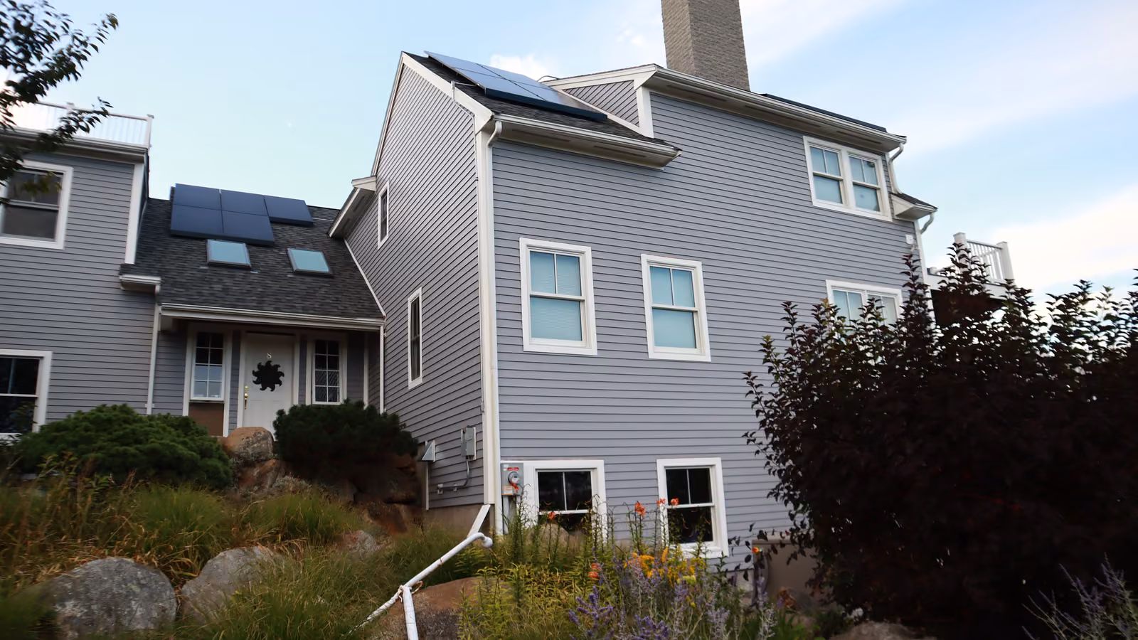Side garden view of a Brookline home with new lap siding and corner trim