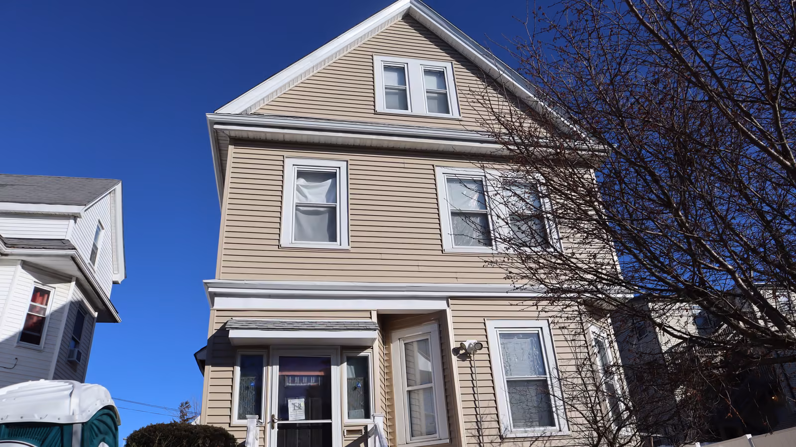 Wide view of a finished multi-family siding project against a clear sky in Dorchester