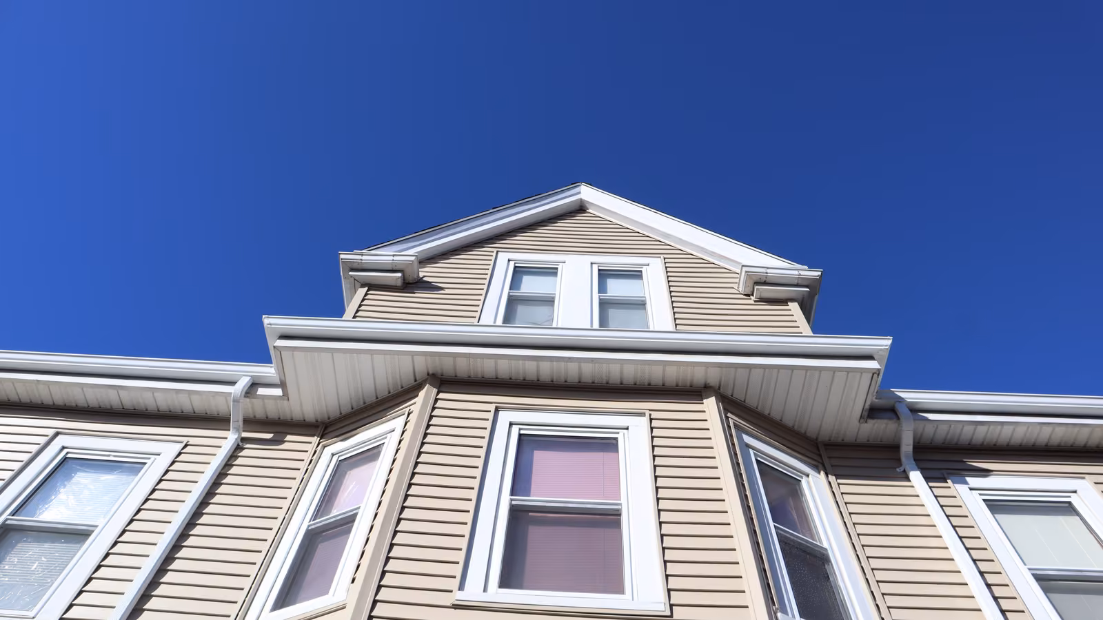 New vinyl siding dormer and roofline detail on a Dorchester multi-family home