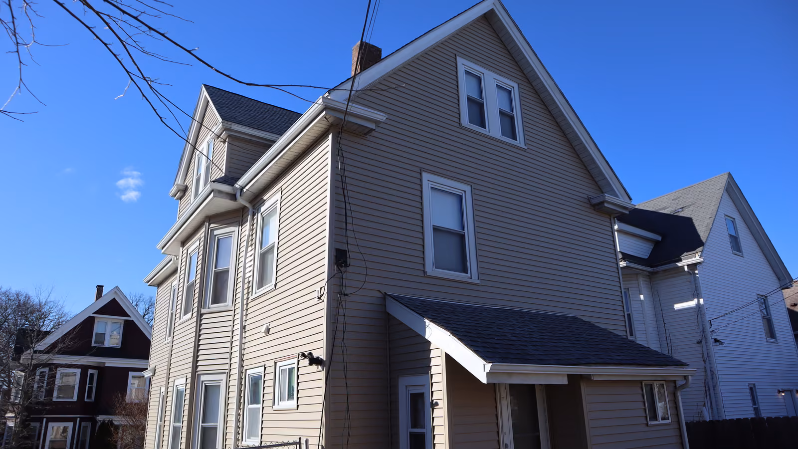 Full side elevation after vinyl siding replacement with new trim around every window