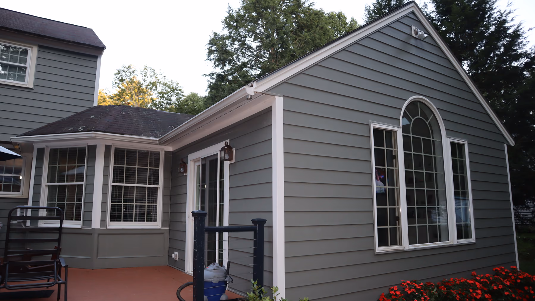 Rear deck of the Holliston home framed by new green siding on the sunroom and back wall