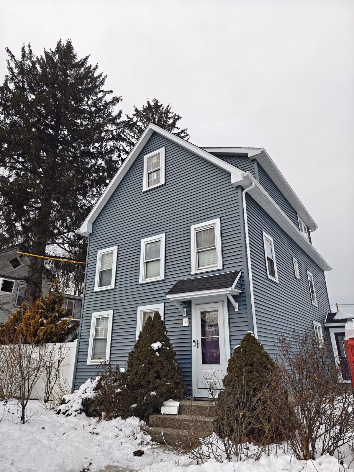 New dark blue vinyl lap siding with white trim on a colonial home in Marlborough, MA