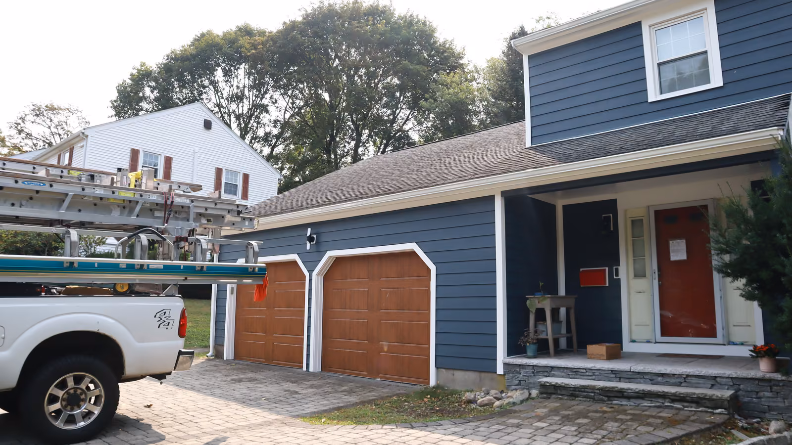 Newton home re-sided in navy lap siding with a two-car garage