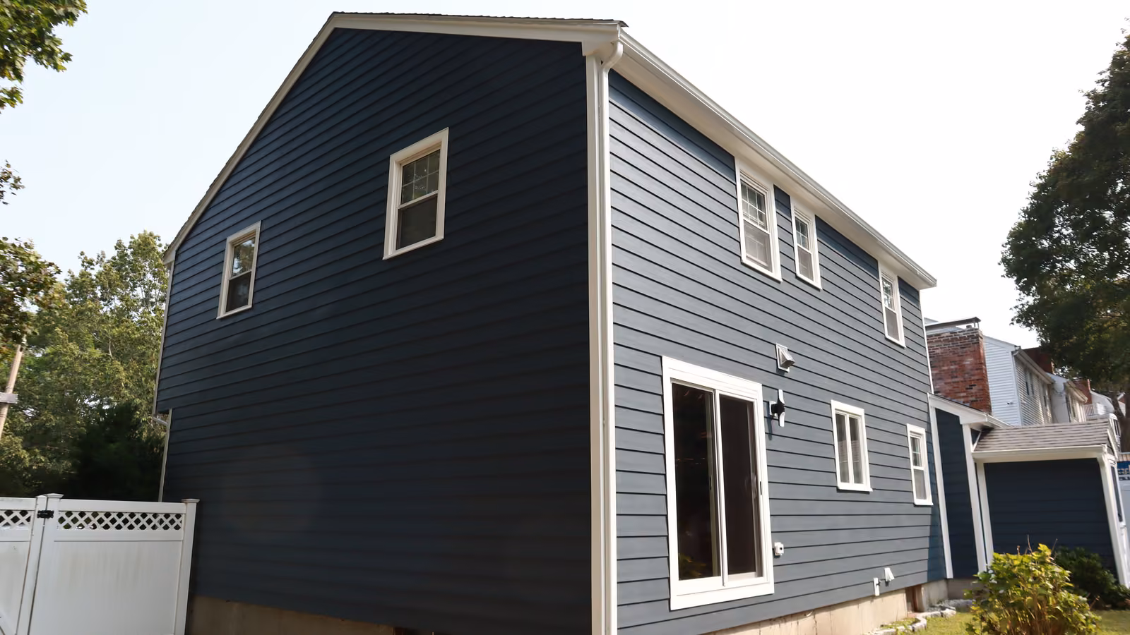 Rear three-quarter view of navy siding with white window trim