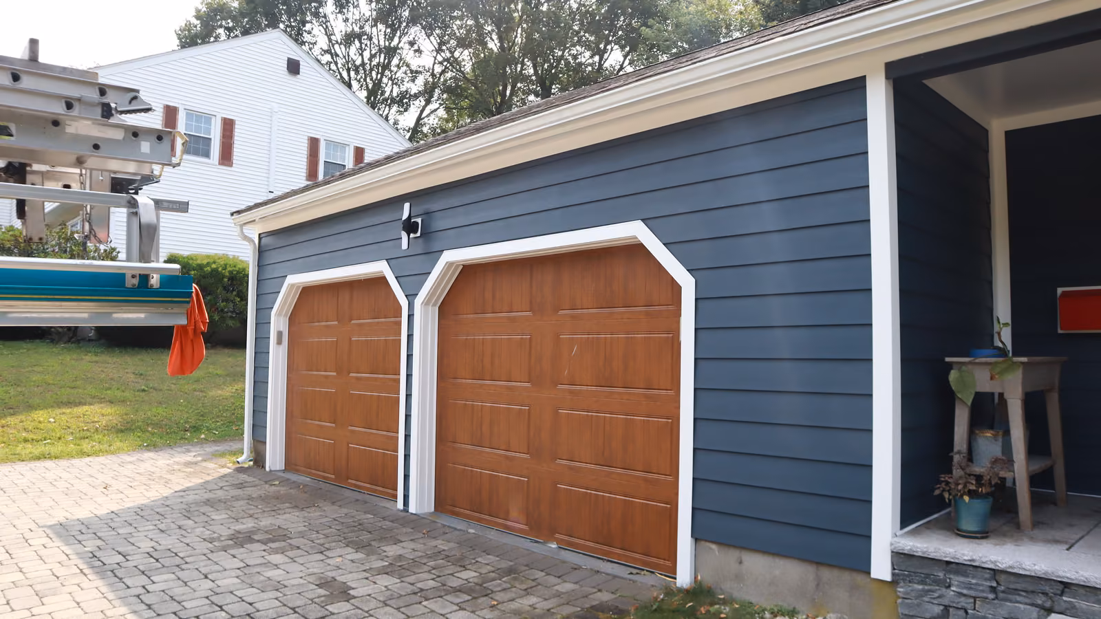Garage clad in navy siding with white trim
