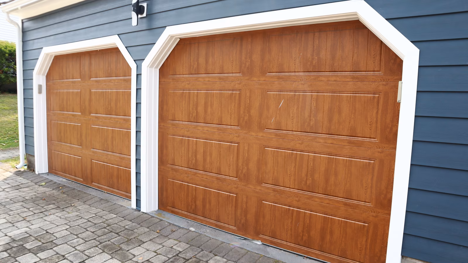 Wood-look garage doors framed in white trim