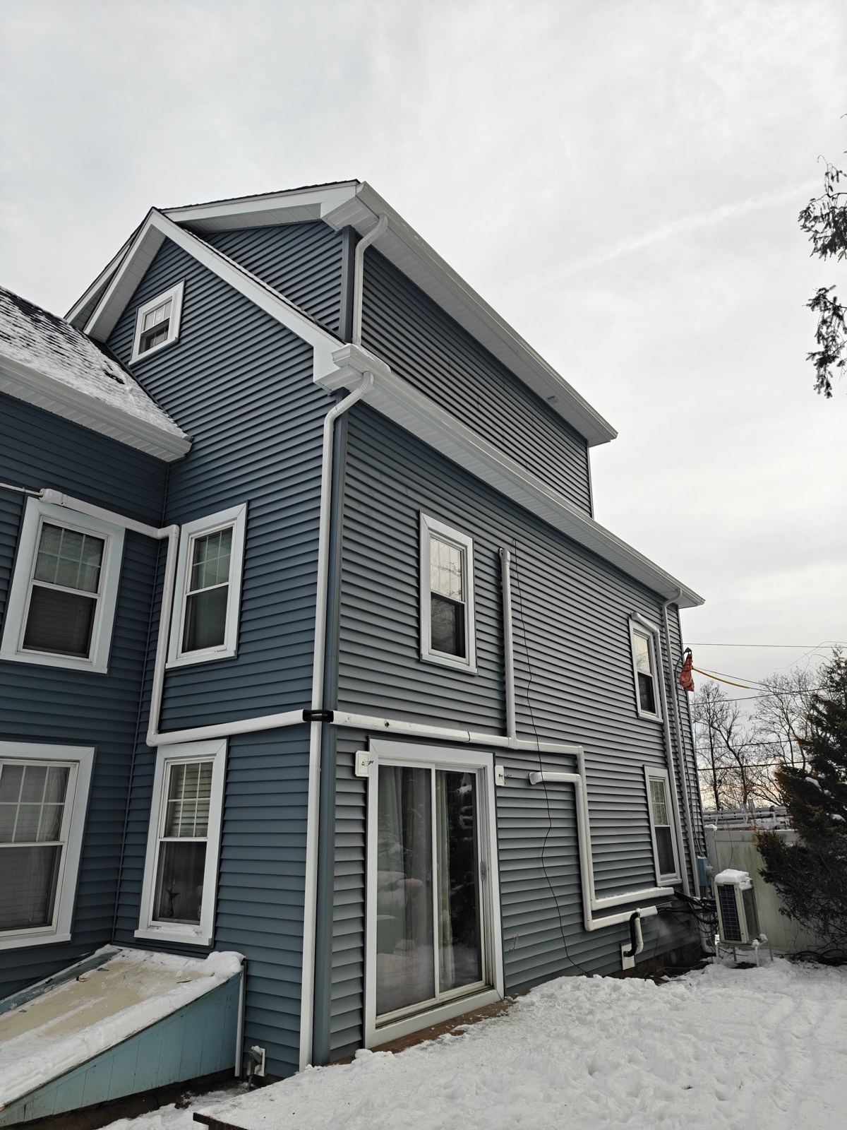 Tall gray-blue elevation showing a gable, dormer and new trim work
